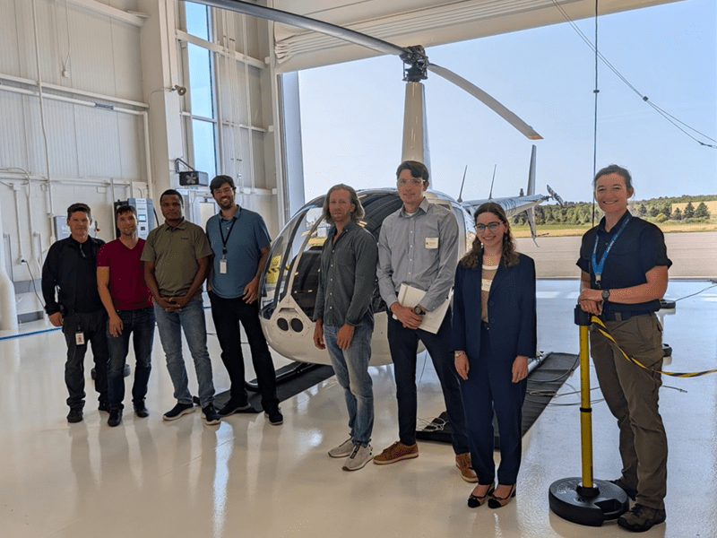 Unither researchers and AGRC students in front of the hydrogen helicopter.]